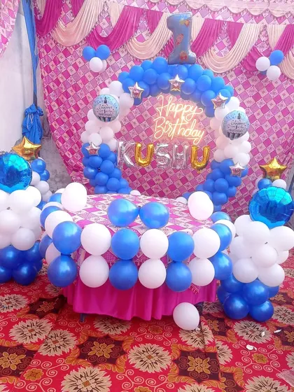 An outdoor birthday setup for a first birthday. The blue and white balloon ring around the cake table creates a festive focal point for the celebration.