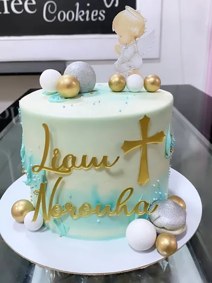 A beautiful baptism cake for Liam Noronha, decorated in serene shades of blue and white with gold accents.
