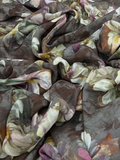 This printed muslin in a muted brown features a soft, watercolor-style floral print. It's a sophisticated and comfortable choice for a dress or tunic.