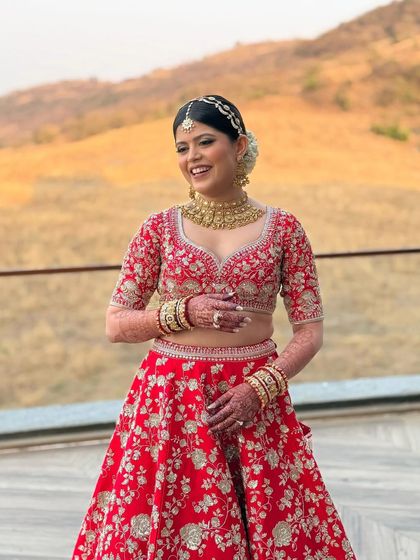 A full-length view of this stunning bride in her red embroidered lehenga. The makeup was kept soft and glowing to balance the richness of her outfit, creating a timeless and elegant bridal statement.