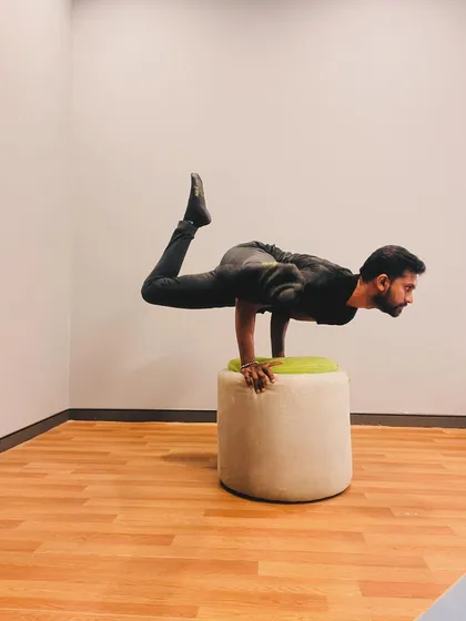 A variation of Peacock Pose with one leg bent. This changes the center of gravity and requires subtle adjustments to maintain balance.