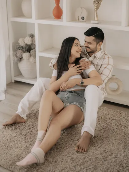 A cozy and intimate portrait from an indoor studio session, capturing the couple in a relaxed, at-home setting.