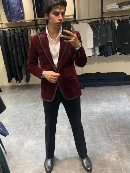 A full-length view of the maroon velvet blazer. Paired with black trousers and a white shirt, it creates a classic and polished cocktail look.