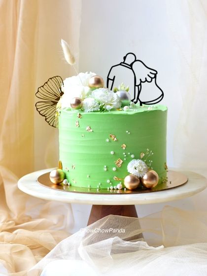 A different angle of the green anniversary cake, showing the delicate floral arrangement.