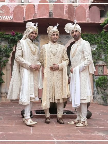 A formal portrait of three grooms, each in a distinct yet coordinated Shauhar sherwani. This is the epitome of regal wedding attire for the groom and his inner circle.