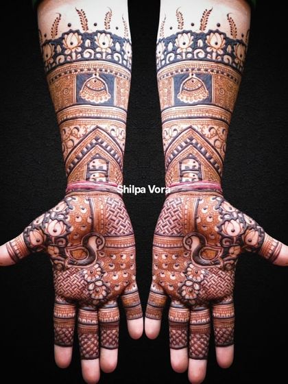 This full-arm bridal design is a masterpiece of traditional art, featuring domes, peacocks, and intricate patterns from fingertips to elbow.