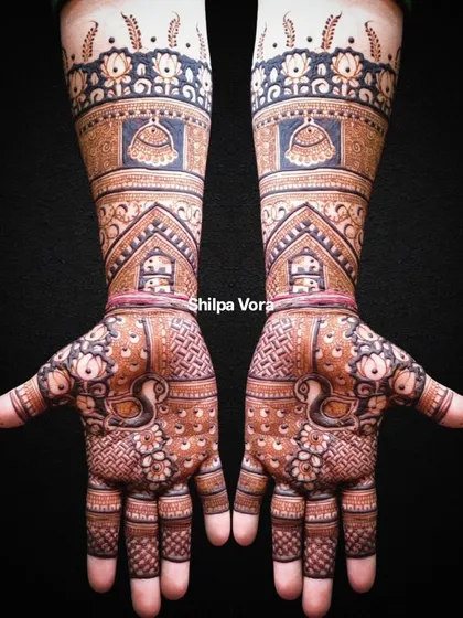 This full-arm bridal design is a masterpiece of traditional art, featuring domes, peacocks, and intricate patterns from fingertips to elbow.