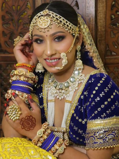 A bride in a royal blue and yellow lehenga with a complete Kundan jewellery set. This showcases a vibrant and traditional Rajasthani bridal look.