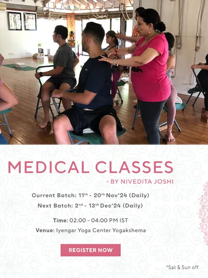 My medical classes are in high demand because they deliver results. This image shows me providing a shoulder adjustment to a student seated on a chair, a common technique for posture correction.