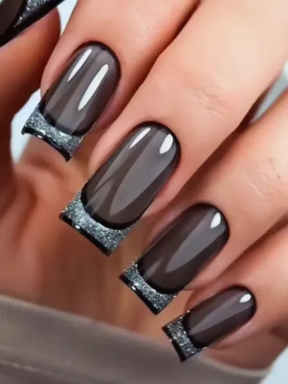A modern take on classic elegance. This design features a translucent "glass" effect on square-tipped extensions, finished with a dramatic, sparkling silver glitter French tip. It's a chic and contemporary style for those who love a sophisticated edge.