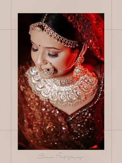 A high-angle close-up of the bride, focusing on her magnificent necklace and flawless makeup.