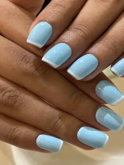 A modern and chic twist on the classic French manicure. This design uses a lovely pastel sky blue as the base color with clean, crisp white tips on neatly shaped square nails for a fresh and stylish look.