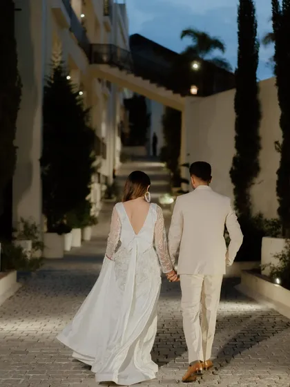 A romantic shot of the couple walking hand-in-hand down a beautifully lit alleyway, stepping into their future together.