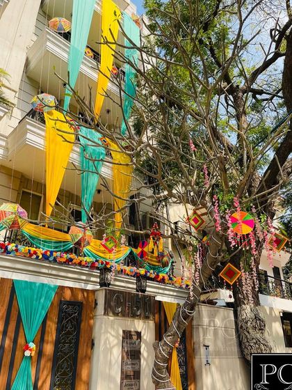 The same home during the day, showing how I decorated the tree with floral strings and traditional hangings to complement the building's decor.
