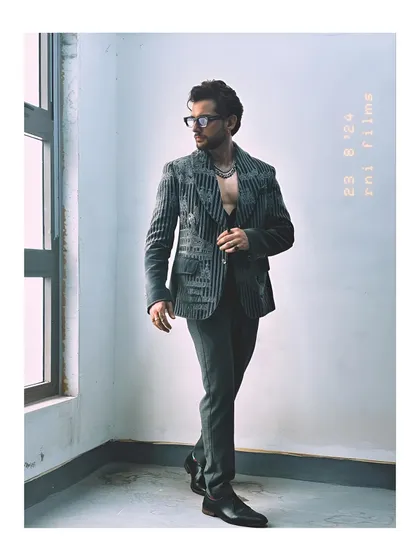 A full-length view of Mohit Hiranandani, showcasing how the embroidered velvet coat can be styled to create a powerful, fashion-forward silhouette.