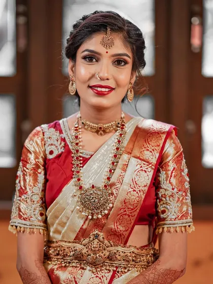 For another engagement function, Swathi wore this traditional red and white saree. I created a classic South Indian makeup look with a bold red lip and traditional jewelry.
