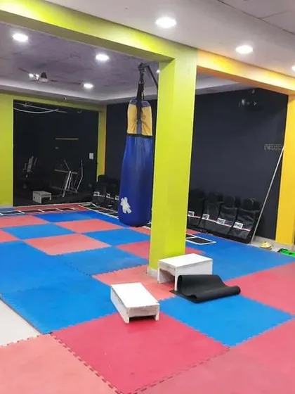 Another view of the martial arts and functional area, showing the punching bag and open matted space. It's a clean, dedicated zone for floor work and dynamic movements.