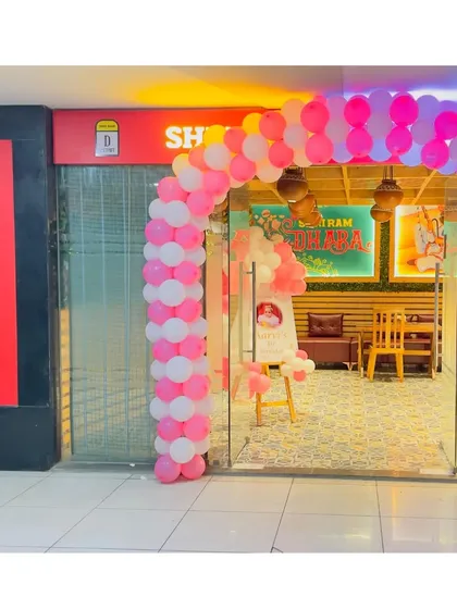 For this first birthday party at a restaurant, I created a welcoming balloon arch in pink and white at the entrance, instantly signaling the celebration inside.