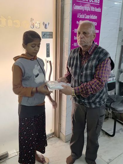 An elderly gentleman from our community receives a donation of warm clothing. It's an honor to serve the elders who have given so much.