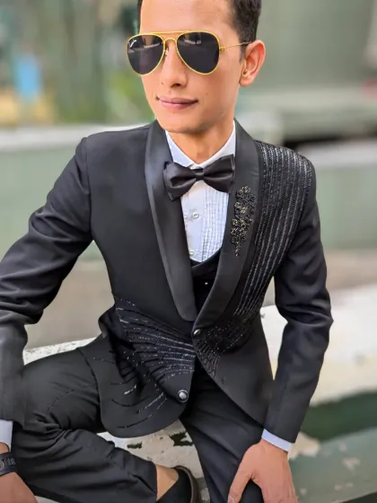 It's not just about the gowns. I ensure he looks just as sharp and stylish. This black tuxedo, with its intricate beadwork and modern cut, is designed for the man who wants to look his absolute best.
