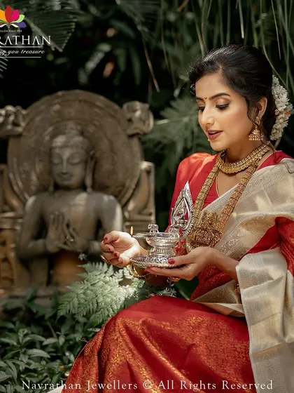 Another angle capturing the divine essence of the bridal look, with the silver lamp adding a touch of sacred tradition to the photograph.