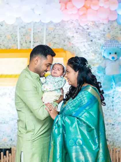 New parents share a loving look as they hold their newborn son during his Naming Ceremony.