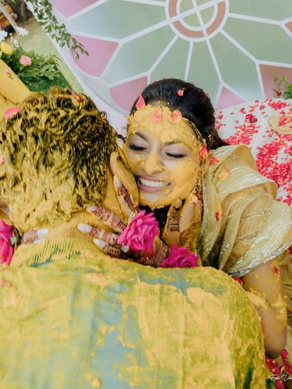 A close up of the bride, Kriti, covered in turmeric and smiling with pure happiness. These are the joyful, unposed moments that truly define the Haldi ceremony.
