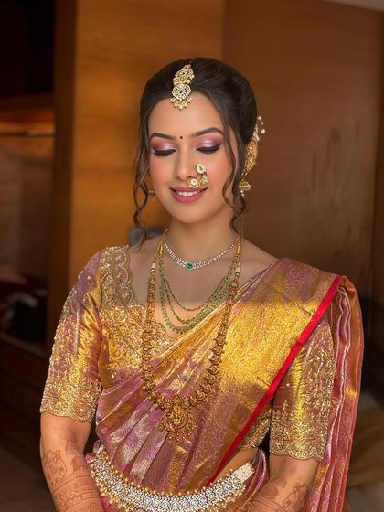 The eye makeup for this Maharashtrian look features soft pink and gold tones, complementing the Paithani saree and creating a look of divine elegance.