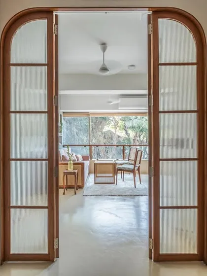 I love creating spaces that can adapt to your life. For this nutrition clinic, I designed these arched, fluted glass doors to beautifully separate the main living area from the workspace, allowing it to transform into a cozy bedroom at night.