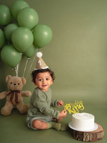 A royal moment for the birthday king. The little crown cake topper and party hat add a festive touch to this stylish, monochromatic green shoot.