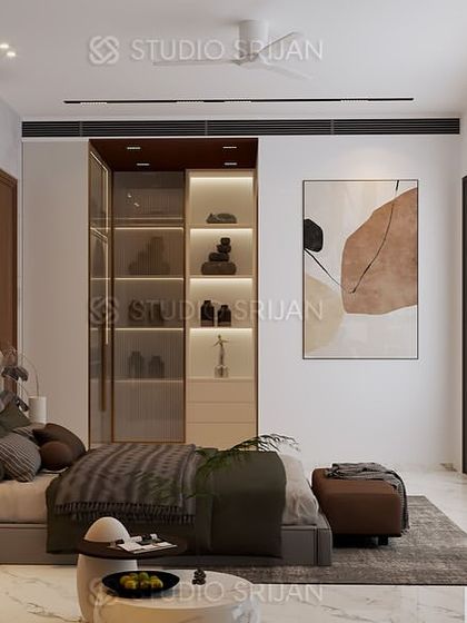 This view shows the bedroom's TV and seating area, with a glass-enclosed shoe and accessory display cabinet that is both functional and stylish.