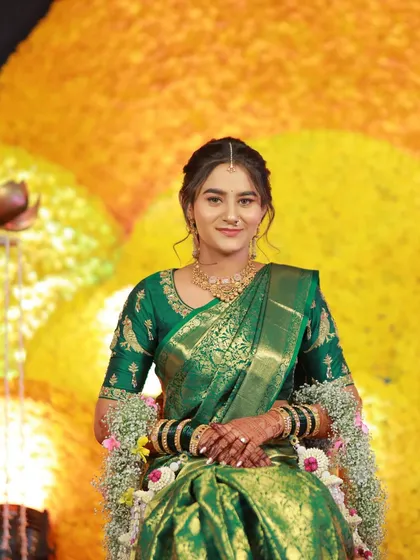 A portrait of a bride in a green saree, beautifully contrasted with our white floral jewellery.