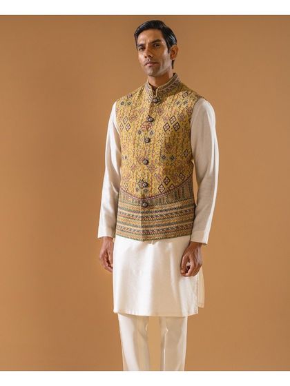 A full-length view of the mustard-yellow embroidered Jawahar jacket, showcasing its unique pattern and overt cuts. It is an essence of timeless elegance for the festive season.