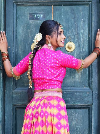 A back view of the model, highlighting the traditional braid and hair accessories that complement our jewellery.