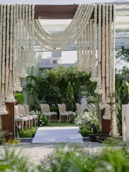 I believe in creating serene and elegant spaces for spiritual moments. Here, I used cascading strings of fresh tuberose and polished teak pillars to frame an outdoor ceremony, transforming a simple lawn into a peaceful, open air sanctum that feels both natural and sacred.
