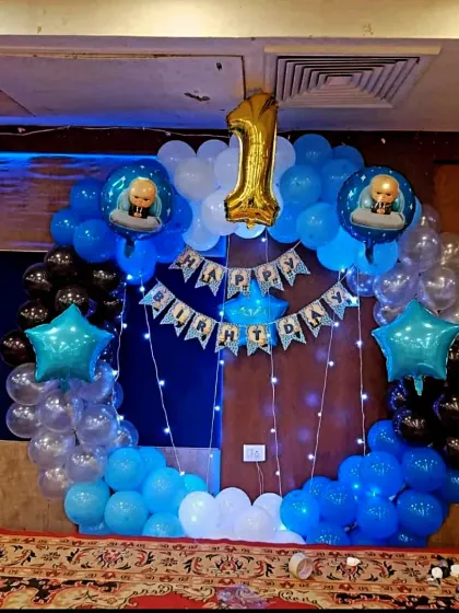 A simple yet effective Boss Baby decor for a first birthday. A circular balloon arch in shades of blue with a "Happy Birthday" banner and star foil balloons made for a lovely backdrop.