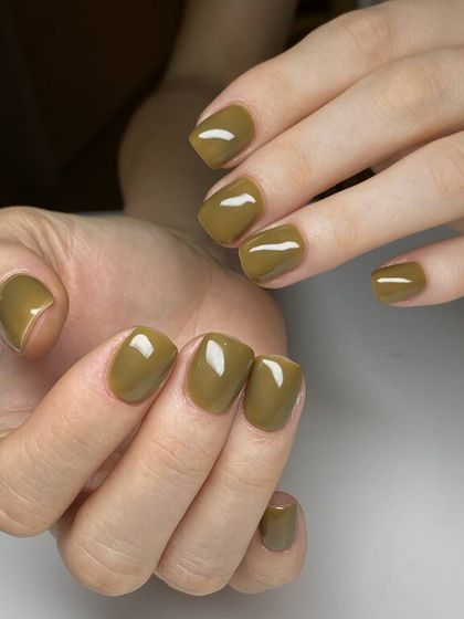 A chic, olive-green manicure on short, square nails. This earthy, muted tone is a stylish and modern alternative to traditional colors.