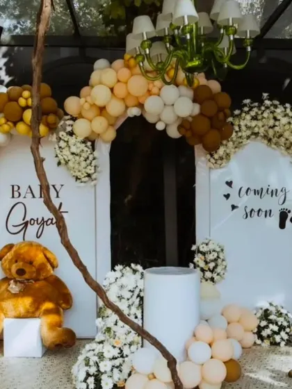 A beautiful teddy bear themed baby shower with arched backdrops, a 'Coming Soon' sign, and a mix of fresh flowers and neutral-toned balloons.