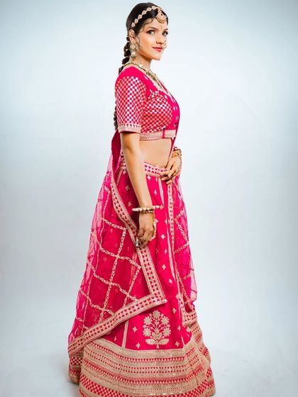 A side view of the pink Marvadi lehenga, showing how the braided hairstyle complements the traditional attire.