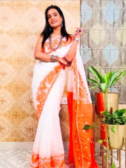 A classic white and orange Jamdani saree. The intricate weaving technique is a heritage craft from Bengal, and it looks so elegant.