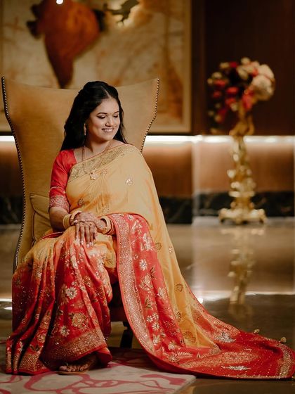 An elegant portrait of the bride seated on a throne-like chair.
