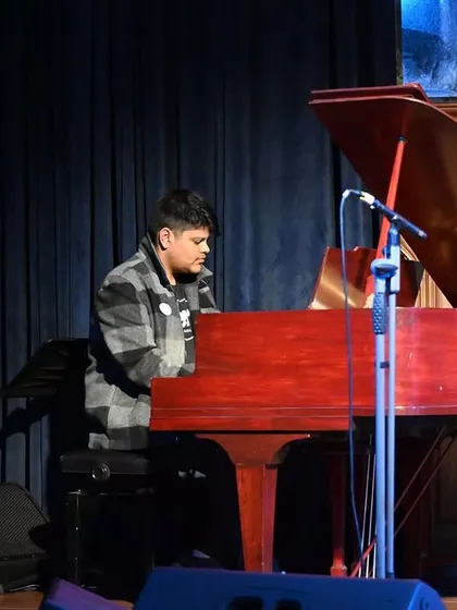 A student at the grand piano, a moment that represents the peak of their practice and dedication throughout the year.