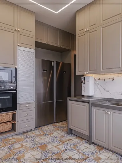 This perspective shows the integration of a double-door refrigerator and appliance unit within the classic sage green kitchen. The design ensures a seamless look while providing all the conveniences of a modern culinary workspace.
