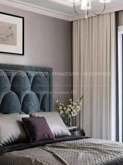A bedroom featuring a uniquely shaped upholstered headboard in a deep blue velvet. The design adds a touch of classic elegance and personality to the space.