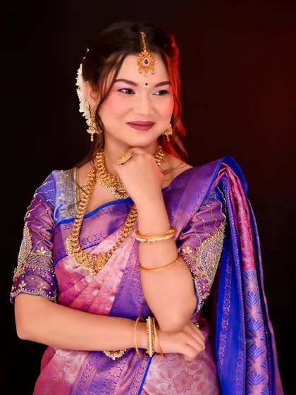 A portrait of a model in a South Indian bridal look, highlighting the complete makeup and silk saree.