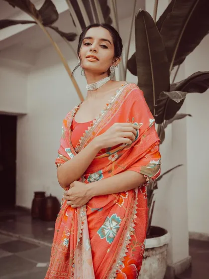 A poised and elegant portrait of a model in a floral print saree. The focus here is on the delicate design and the model's graceful expression, creating a timeless and sophisticated fashion shot.