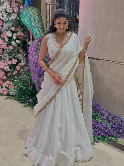 Another look at this timeless white and gold Indian outfit. The way the fabric drapes, combined with the elegant gold border, makes it a perfect choice for any festive family evening.