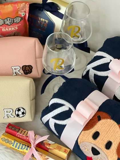 Here are the personalized goodies from the football and fur-baby themed wedding hamper. It includes initialed wine glasses and custom pouches with football and dog-themed patches.