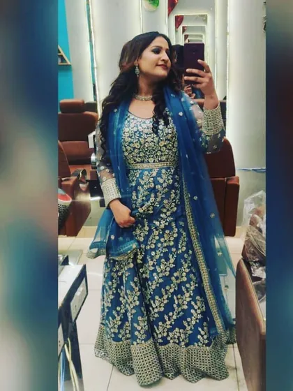 A client taking a mirror selfie in a beautiful blue embroidered anarkali gown. This is a great rental option for someone who wants a full-length silhouette without the hassle of a lehenga.
