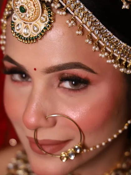 A close-up of our gracious Rajwada bride. The focus here is on the eyes, with a soft glittery finish and perfectly defined brows, paired with a classic nude lip to balance the heavy jewelry.